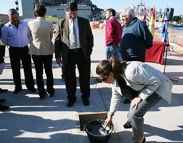 La directora general de Transportes y Puertos, Carmen Sandoval, pone la primera piedra de las obras de la nueva infraestructura que el Gobierno regional construirá en el puerto de Águilas para mejorar las condiciones de trabajo de los pescadores de la localidad.